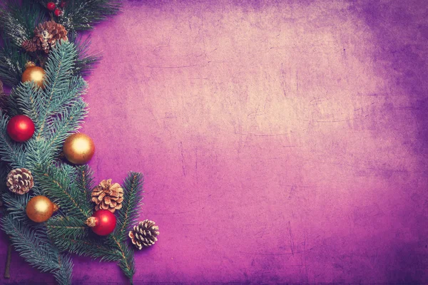 Pine branch and toys on violet background. — Stock Photo, Image