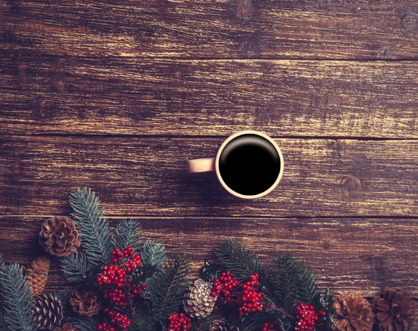 Cup of coffee next to pine bracnch on wooden table. — Stock Photo, Image