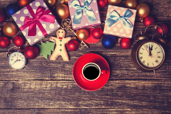 Cup of coffee next to christmas toys on wooden table. — Stock Photo, Image