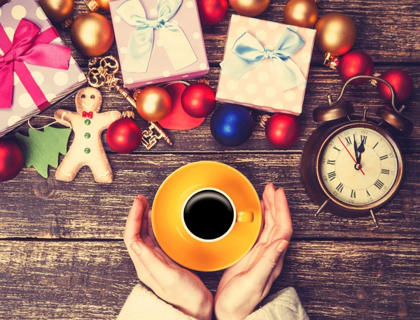 Female holding cup of coffee near christmas gifts on a table — Stock Photo, Image