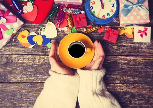 Ženské hospodářství šálek kávy u vánoční dárky na stůl — Stock fotografie