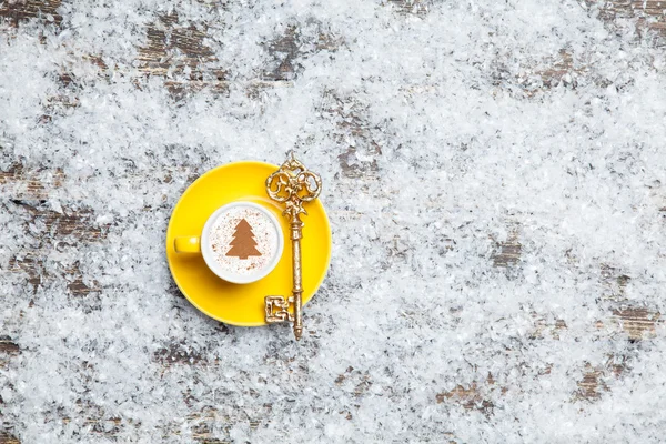 Cappuccino con albero di Natale a forma di chiave sulla neve artificiale — Foto Stock