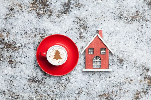 Cappuccino con albero di Natale a forma di casa e giocattolo su artificiale — Foto Stock