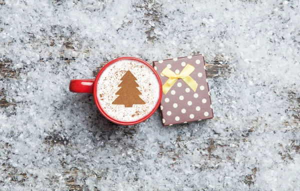 Kapuçino üzerinde yapay Noel ağacı şekil ve hediye kutusu — Stok fotoğraf