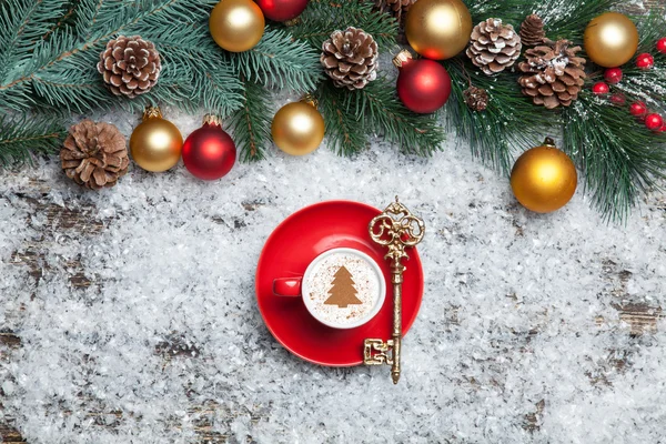 Cappuccino with christmas tree shape and key on artificial snow — Stock Photo, Image