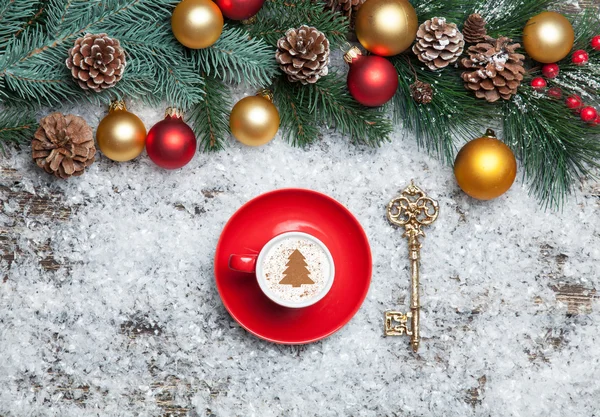 Cappuccino med julgran form och nyckel på konstsnö — Stockfoto
