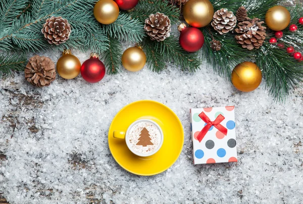 Капучино с рождественской елкой и подарочной коробкой на искусственном — стоковое фото