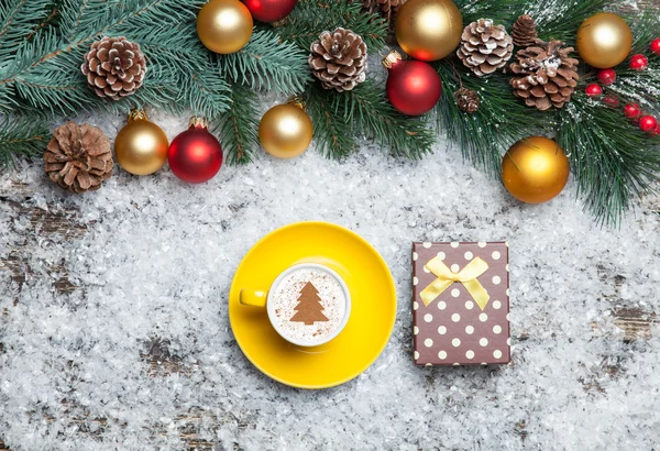 Cappuccino with christmas tree shape and gift box on artificial — Stock Photo, Image