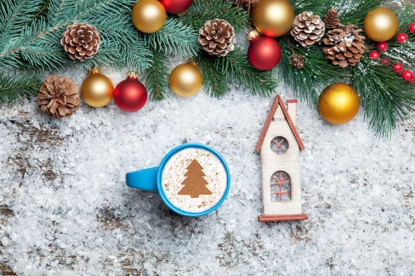 Cappuccino with christmas tree shape and toy home on artificial — Stock Photo, Image