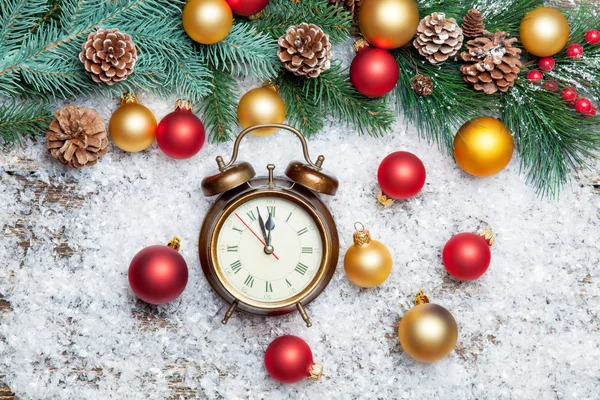 Alarm clock and pine branch with toys. — Stock Photo, Image