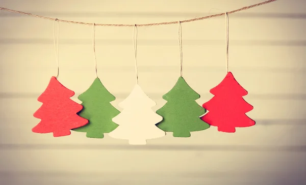 Fünf Weihnachtsbaumspielzeuge hängen am Jutefaden. — Stockfoto