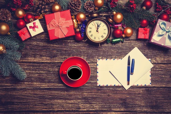 Hot coffee with letter near christmas gifts on wooden table. — Stock Photo, Image