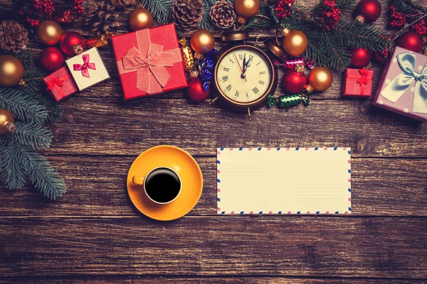 Hot coffee with letter near christmas gifts on wooden table. — Stock Photo, Image
