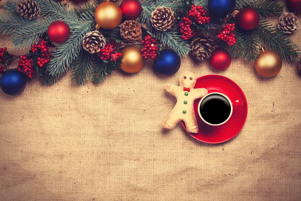 Café chaud et biscuit sur une table près des branches de pin — Photo