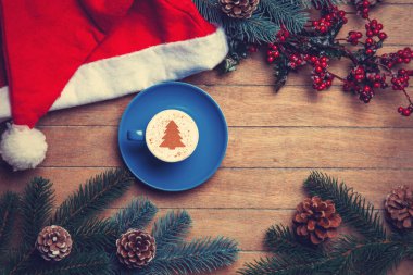 Kapuçino Noel şapka ve çam ahşap tablo.