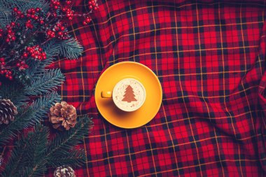 Tartan zemin üzerine cappuccino ve çam dalı
