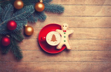 Kapuçino ahşap masa zencefilli kurabiye adam ve çam dalı ile.