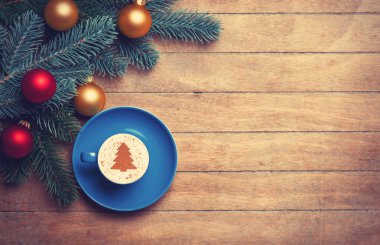 Ahşap masa cappuccino ve çam dalı.