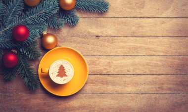 Ahşap masa cappuccino ve çam dalı.