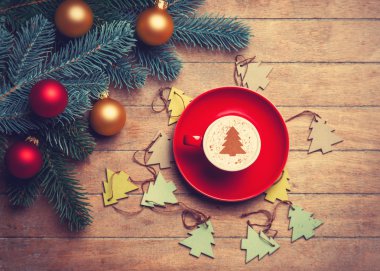 Ahşap masa cappuccino ve çam dalı.