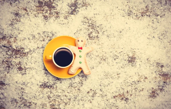 Kaffee mit Lebkuchenmann auf Kunstschnee-Hintergrund — Stockfoto