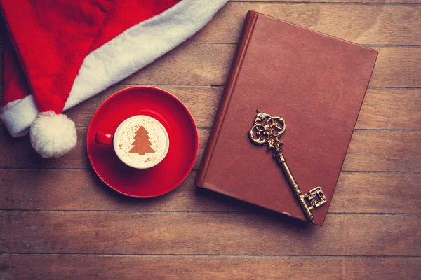 Cappuccino con llave y libro sobre mesa de madera . —  Fotos de Stock