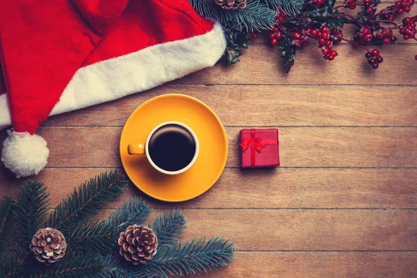 Taza de café y caja de regalo con pino y sombrero en mesa de madera . —  Fotos de Stock