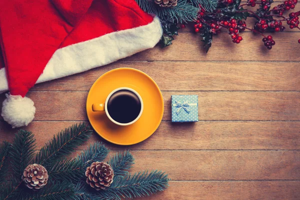 Taza de café y caja de regalo con pino y sombrero en mesa de madera . —  Fotos de Stock