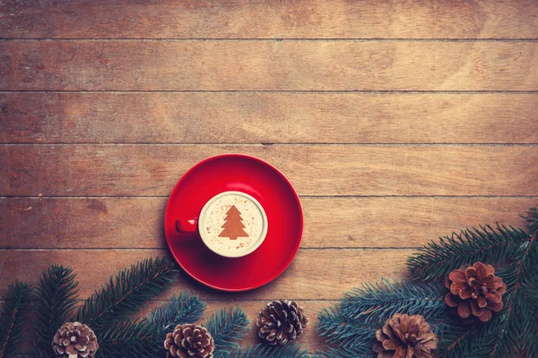 Cappuccino and  pine branch on wooden table. — Stock Photo, Image