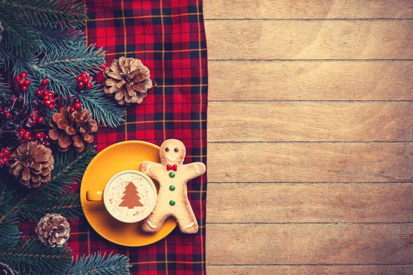 Kapuçino ahşap masa zencefilli kurabiye adam ve çam dalı ile.