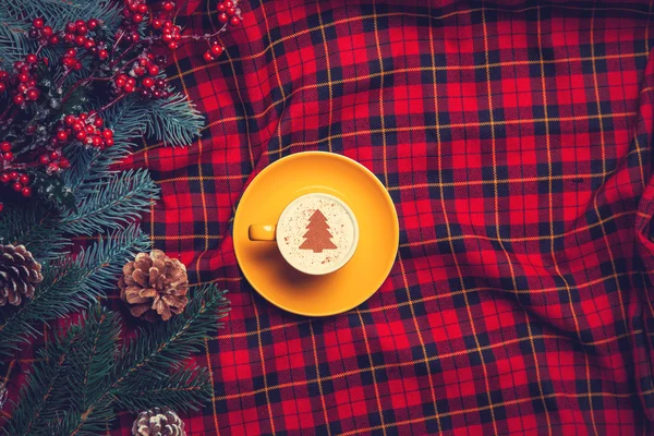 Tartan zemin üzerine cappuccino ve çam dalı