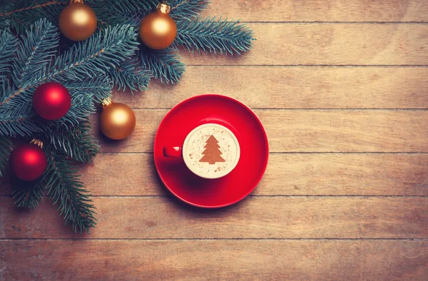 Cappuccino e ramo di pino sul tavolo di legno . — Foto Stock