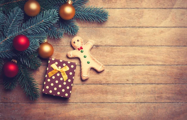 Gingerbread man and gift on wooden table. — Stock Photo, Image