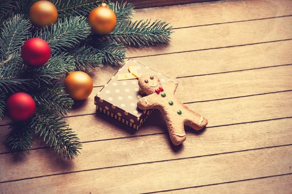 Gingerbread man and gift on wooden table. — Stock Photo, Image
