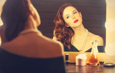 Yakınındaki bir ayna makyaj uygulamak olarak güzel bir kadın portresi