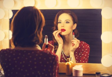 Yakınındaki bir ayna makyaj uygulamak olarak güzel bir kadın portresi