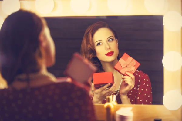 Retrato de uma mulher bonita como aplicação de maquiagem perto de um espelho — Fotografia de Stock