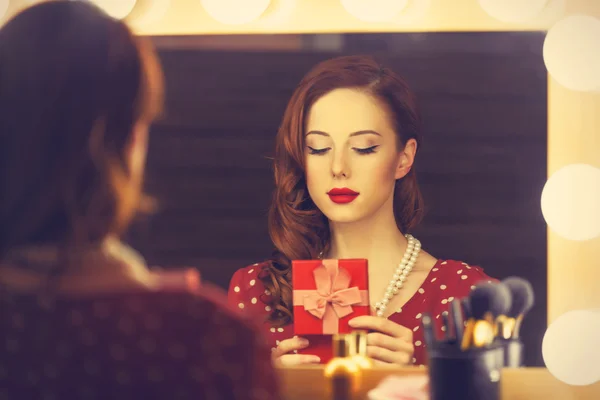 Portret van een mooie vrouw als toepassing van make-up in de buurt van een spiegel — Stockfoto