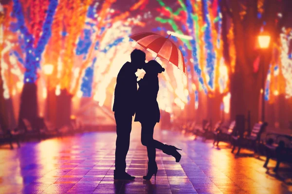Couple with umbrella kissing at night alley. — Stock Photo, Image