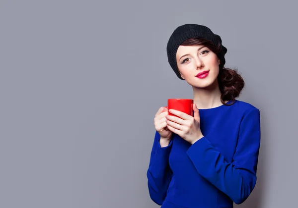 Frauen in blauem Kleid mit roter Tasse — Stockfoto
