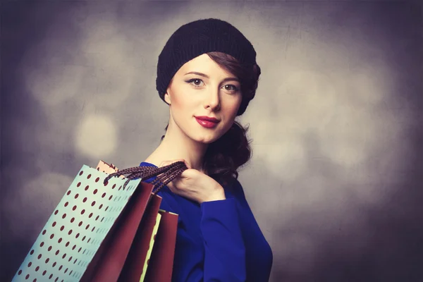 Vrouwen in blauwe jurk met shopping tassen — Stockfoto