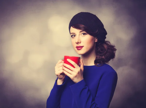 Kvinnor i blå klänning med röd kopp — Stockfoto