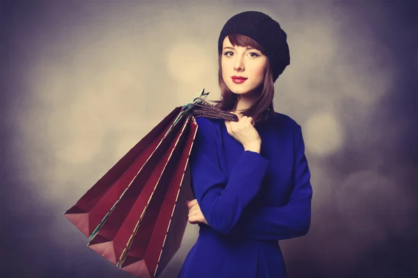 Femmes en robe bleue avec des sacs à provisions — Photo