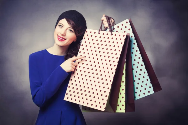 Vrouwen in blauwe jurk met shopping tassen — Stockfoto