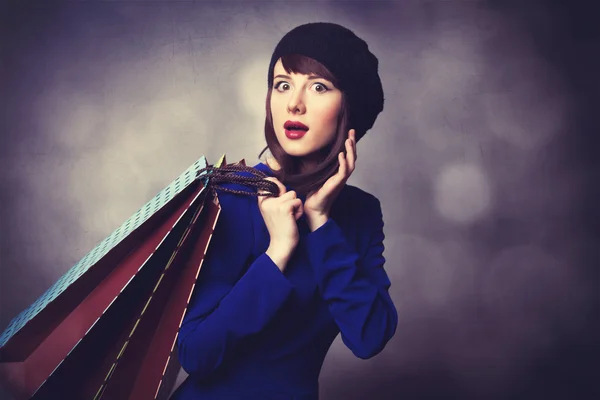 Vrouwen in blauwe jurk met shopping tassen — Stockfoto
