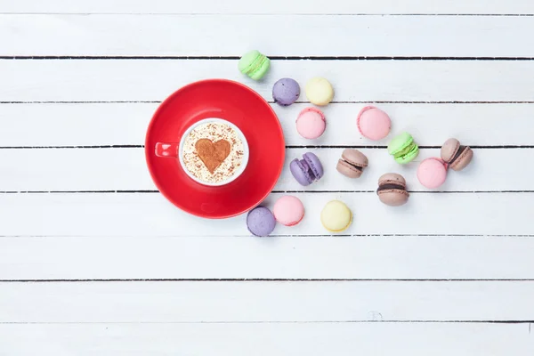 Cappuccino con símbolo en forma de corazón y macaron —  Fotos de Stock