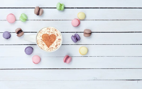 Cappuccino con símbolo en forma de corazón y macaron — Foto de Stock