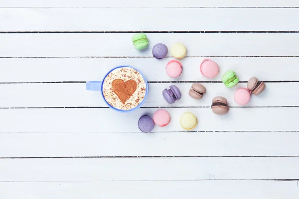 Cappuccino with heart shape symbol and macaron — Stock Photo, Image