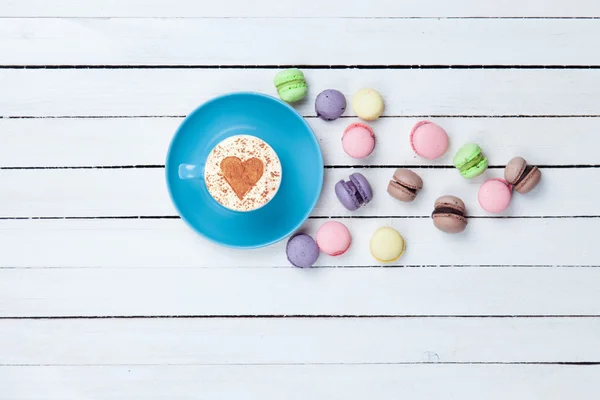 Cappuccino with heart shape symbol and macaron — Stock Photo, Image