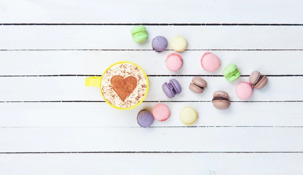 Cappuccino con símbolo en forma de corazón y macaron —  Fotos de Stock